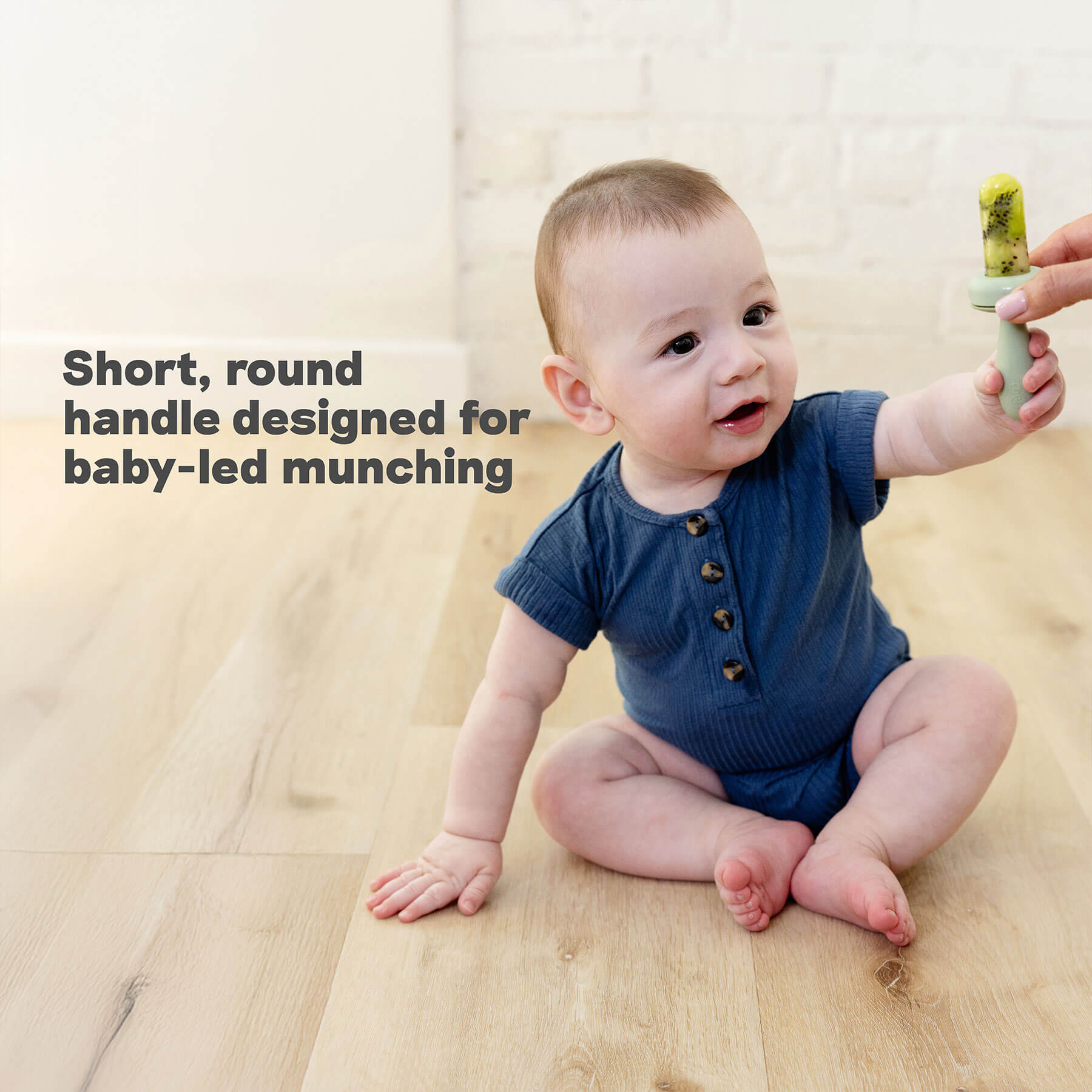 ezpz silicone gumline feeder has a short round handle designed for baby-led munching