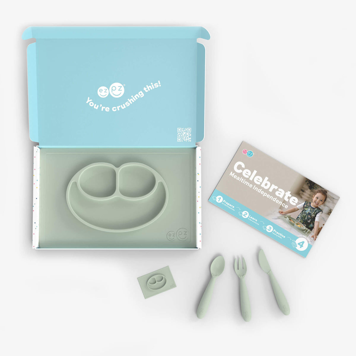 ezpz Kit 4 - Celebrate Mealtime Independence in Sage Green includes the Happy Mat, Happy Utensils, and Micro Mat