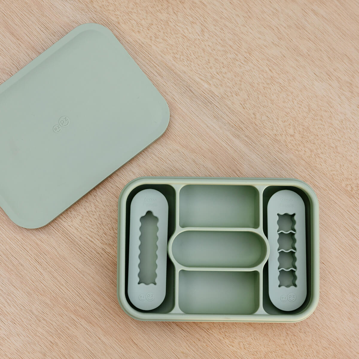 ezpz travel box in sage green is an all-in-one feeding + storage system that helps families pack, transport, and serve baby’s meals when away from home