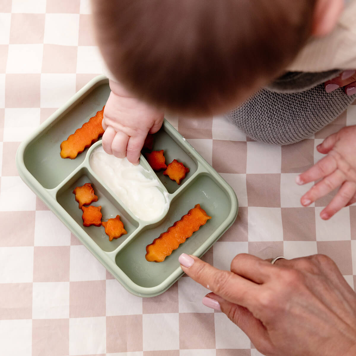 ezpz travel box in sage green is an all-in-one feeding + storage system that helps families pack, transport, and serve baby’s meals when away from home