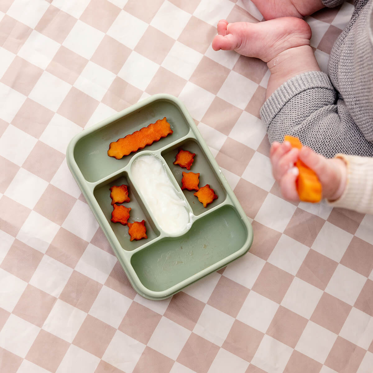 ezpz travel box in sage green is an all-in-one feeding + storage system that helps families pack, transport, and serve baby’s meals when away from home