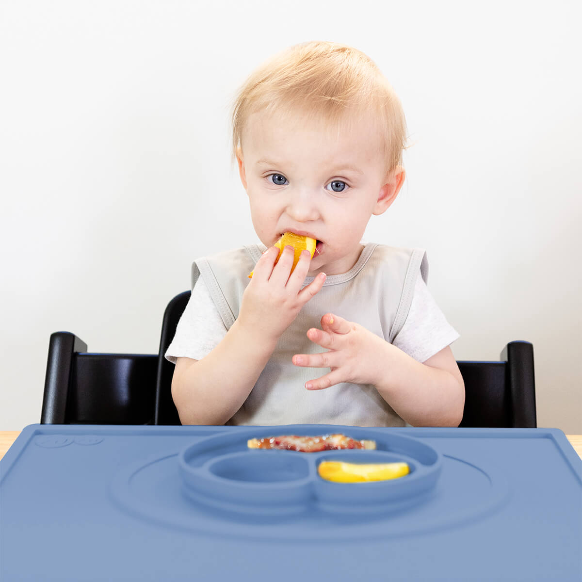ezpz Mini Placemat in Indigo Blue is a silicone placemat for toddlers that grips to the table