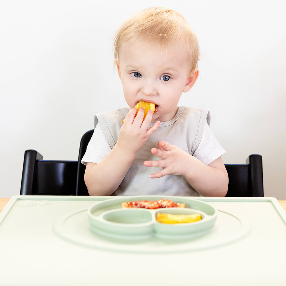ezpz Mini Placemat in Sage Green is a silicone placemat for toddlers that grips to the table