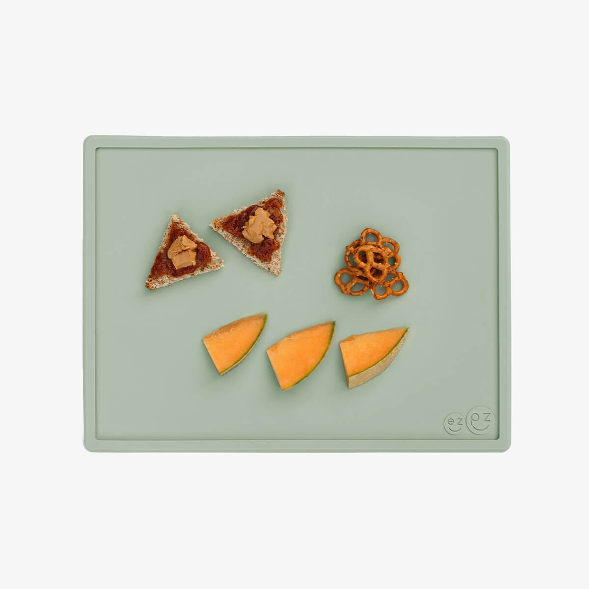 ezpz Mini Placemat in Sage Green is a silicone placemat for toddlers that grips to the table