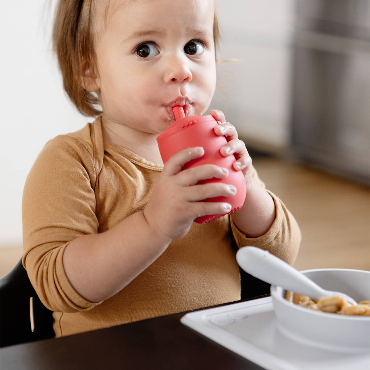 The Mini Cup + Straw in Coral by ezpz / Silicone Drinking Cup and Straw Training System for Toddlers