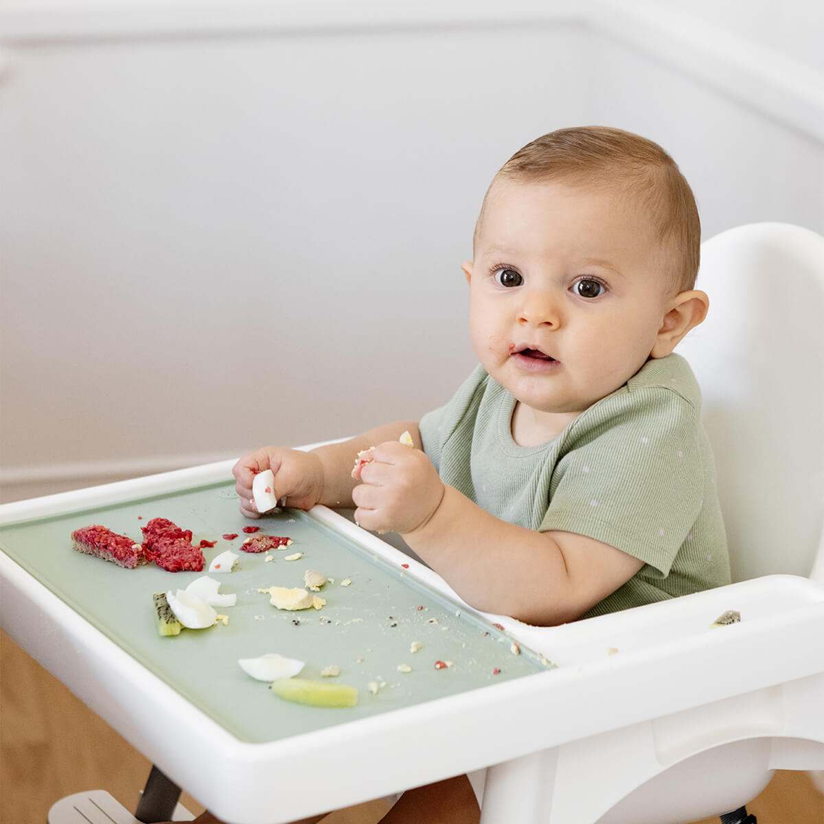 The Tiny Placemat in Sage is a non-slip, silicone placemat that fits on most highchair trays