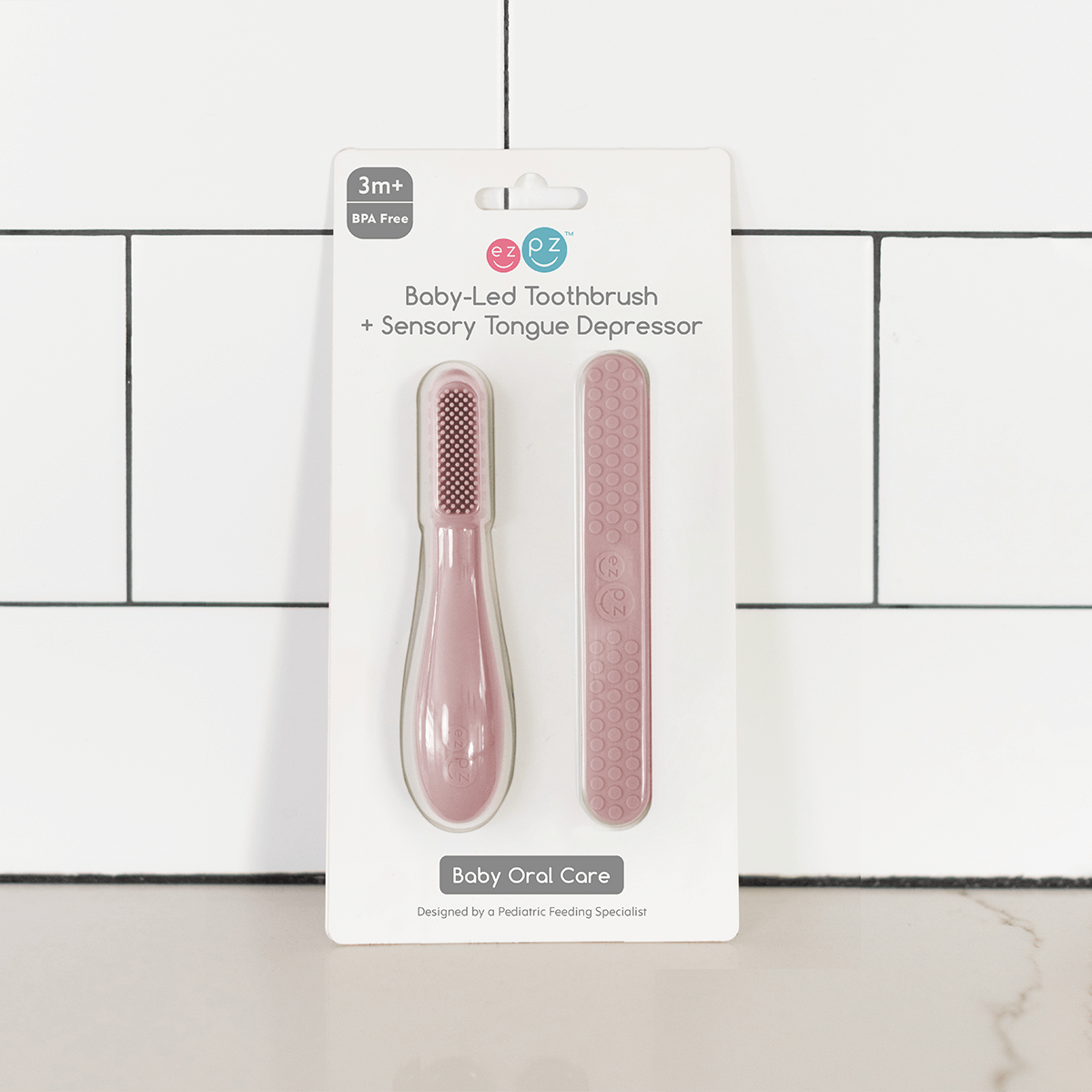 ezpz baby led toothbrush and sensory tongue depressor in blush pink