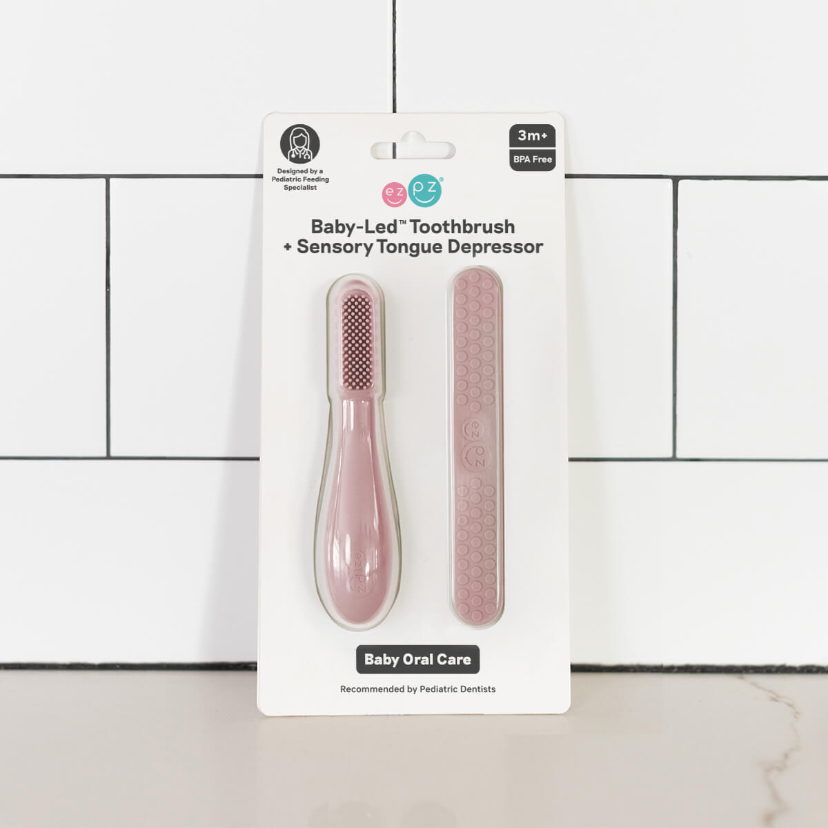 ezpz baby led toothbrush and sensory tongue depressor in blush pink