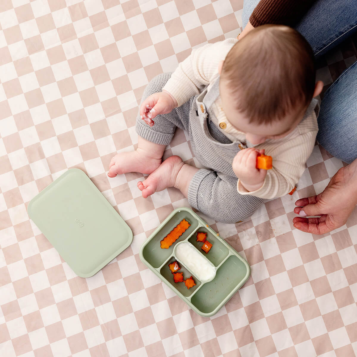 ezpz travel box in sage green is an all-in-one feeding + storage system that helps families pack, transport, and serve baby’s meals when away from home 