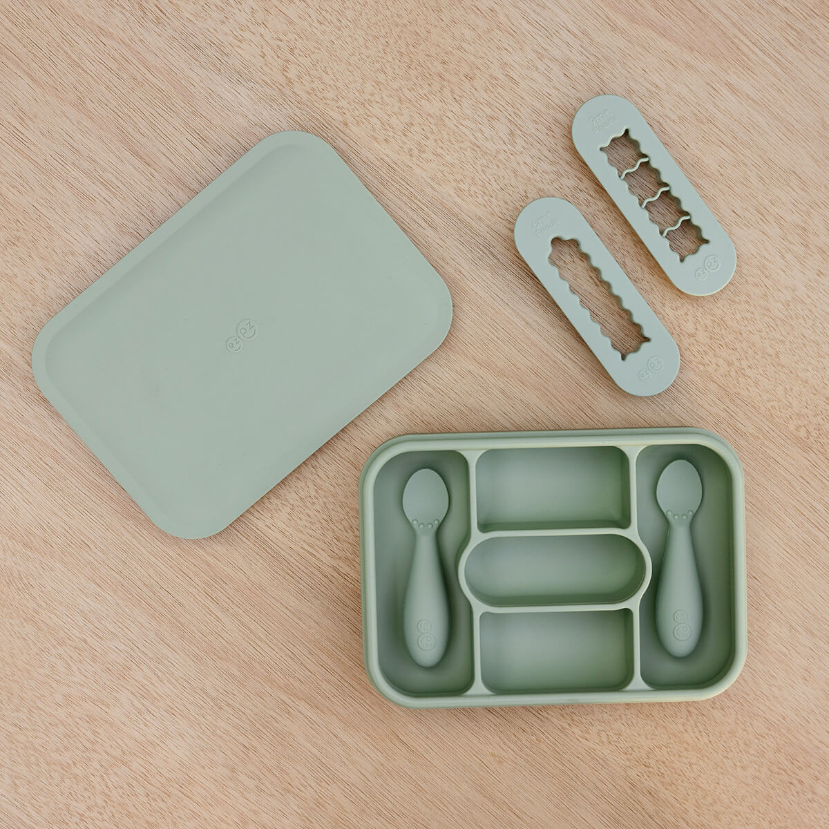 ezpz travel box in sage green is an all-in-one feeding + storage system that helps families pack, transport, and serve baby’s meals when away from home 