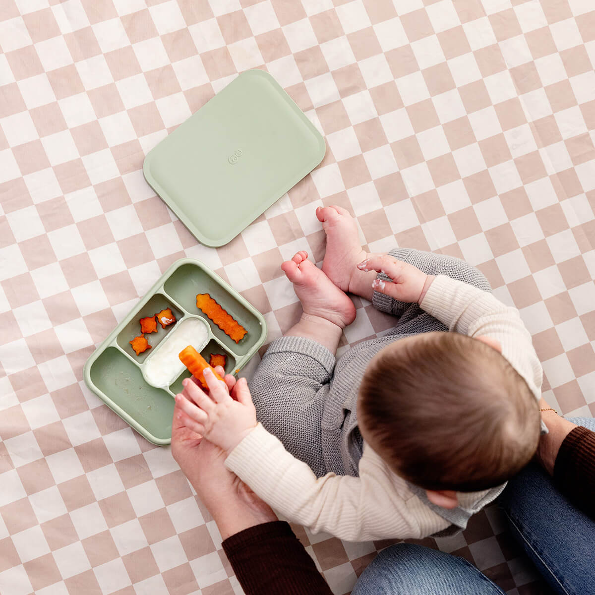 ezpz travel box in sage green is an all-in-one feeding + storage system that helps families pack, transport, and serve baby’s meals when away from home 