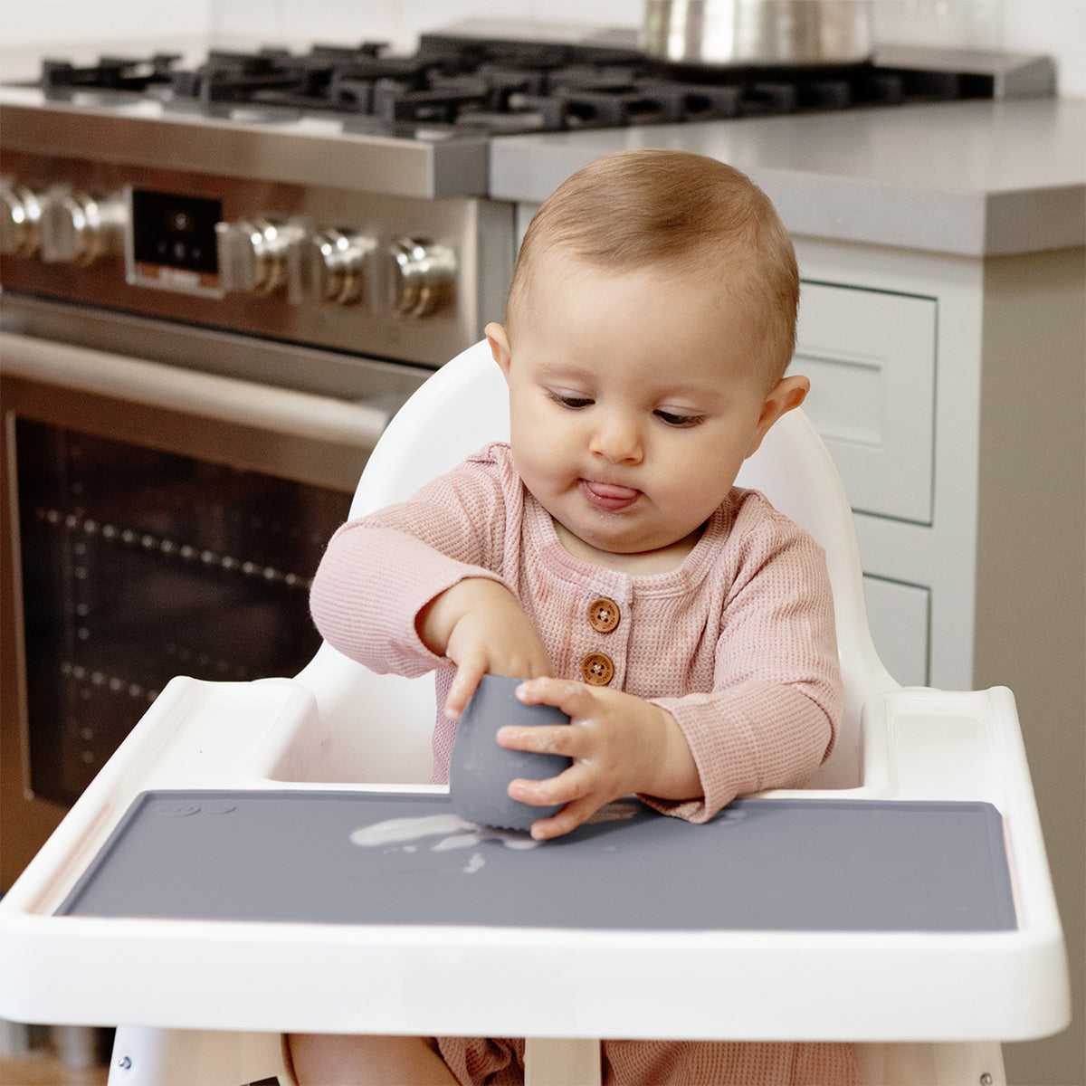 The Tiny Placemat in Gray is a non-slip, silicone placemat that fits on most highchair trays
