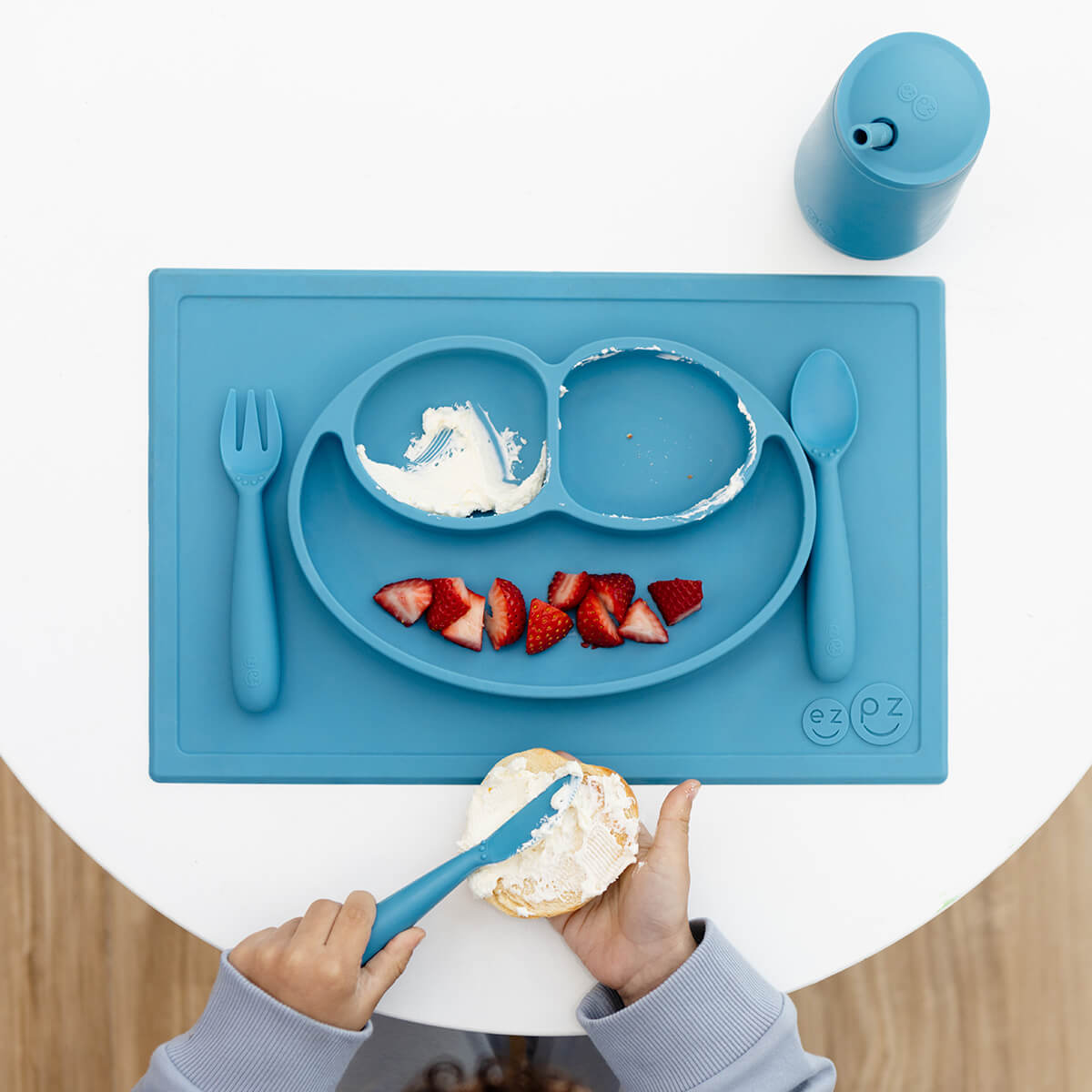 ezpz Happy Feeding Set in Blue / Silicone, Self-Suctioning Plate, Silicone Cup and Straw, Training Utensils for Toddlers