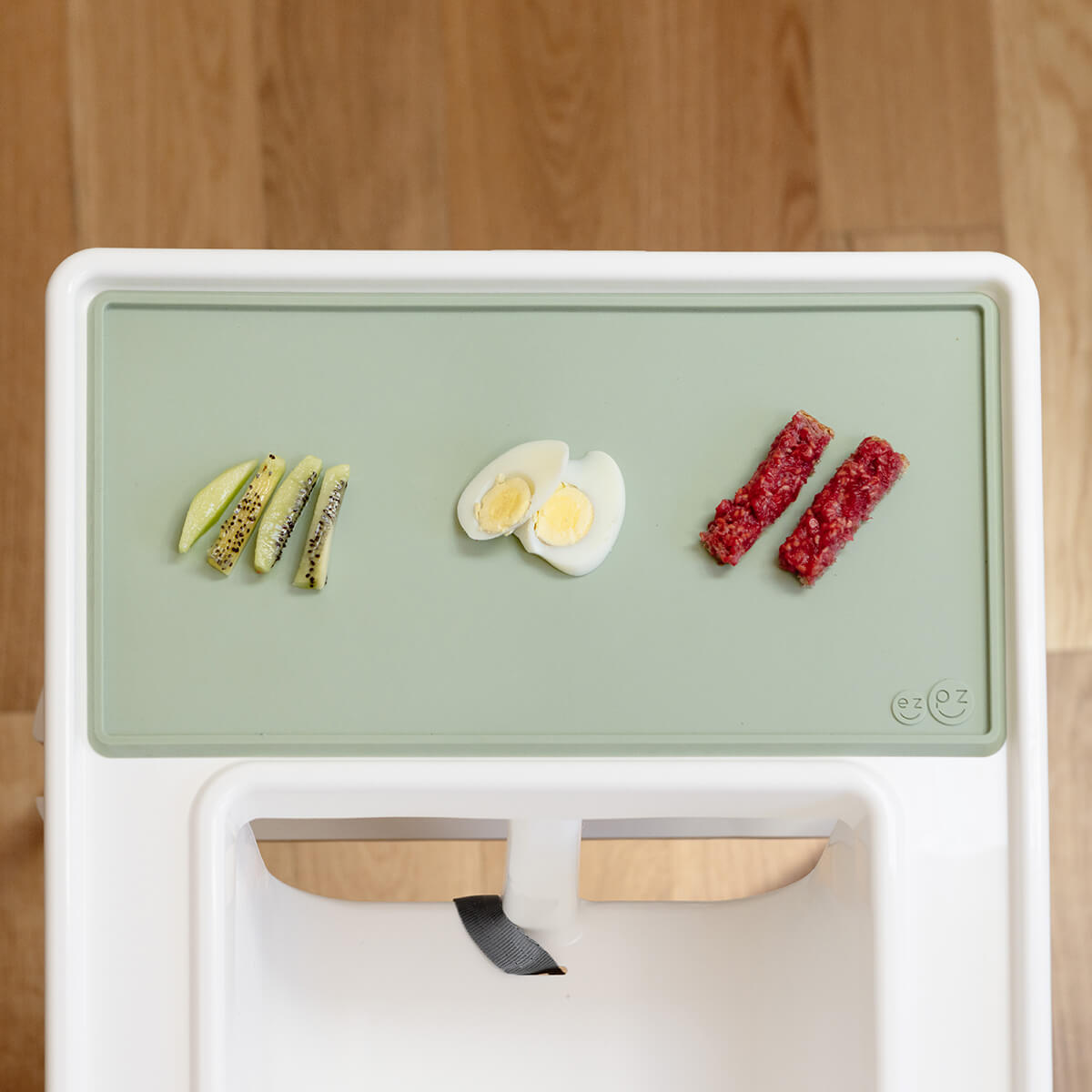 The Tiny Placemat in Sage is a non-slip, silicone placemat that fits on most highchair trays