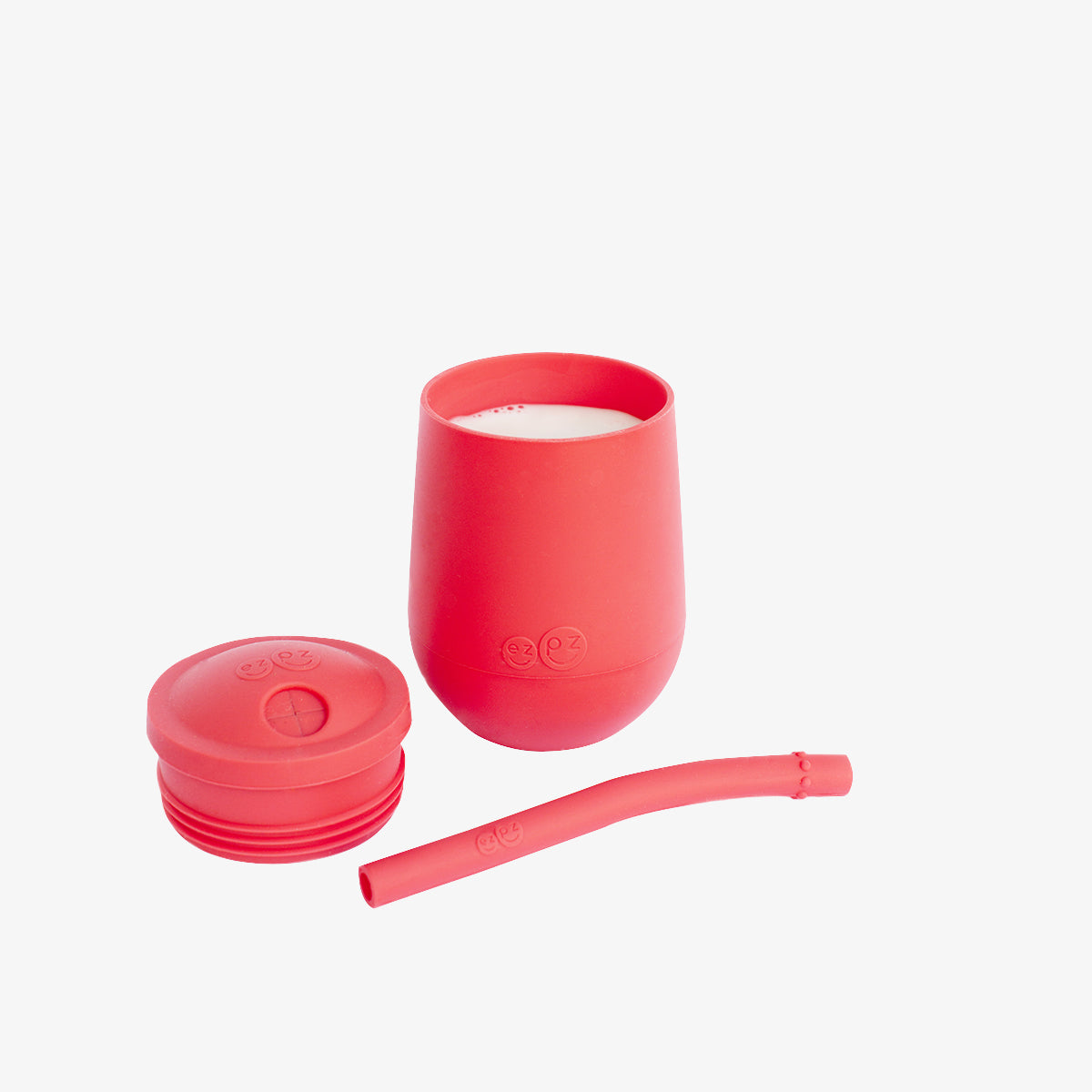 The Mini Cup + Straw in Coral by ezpz / Silicone Drinking Cup and Straw Training System for Toddlers